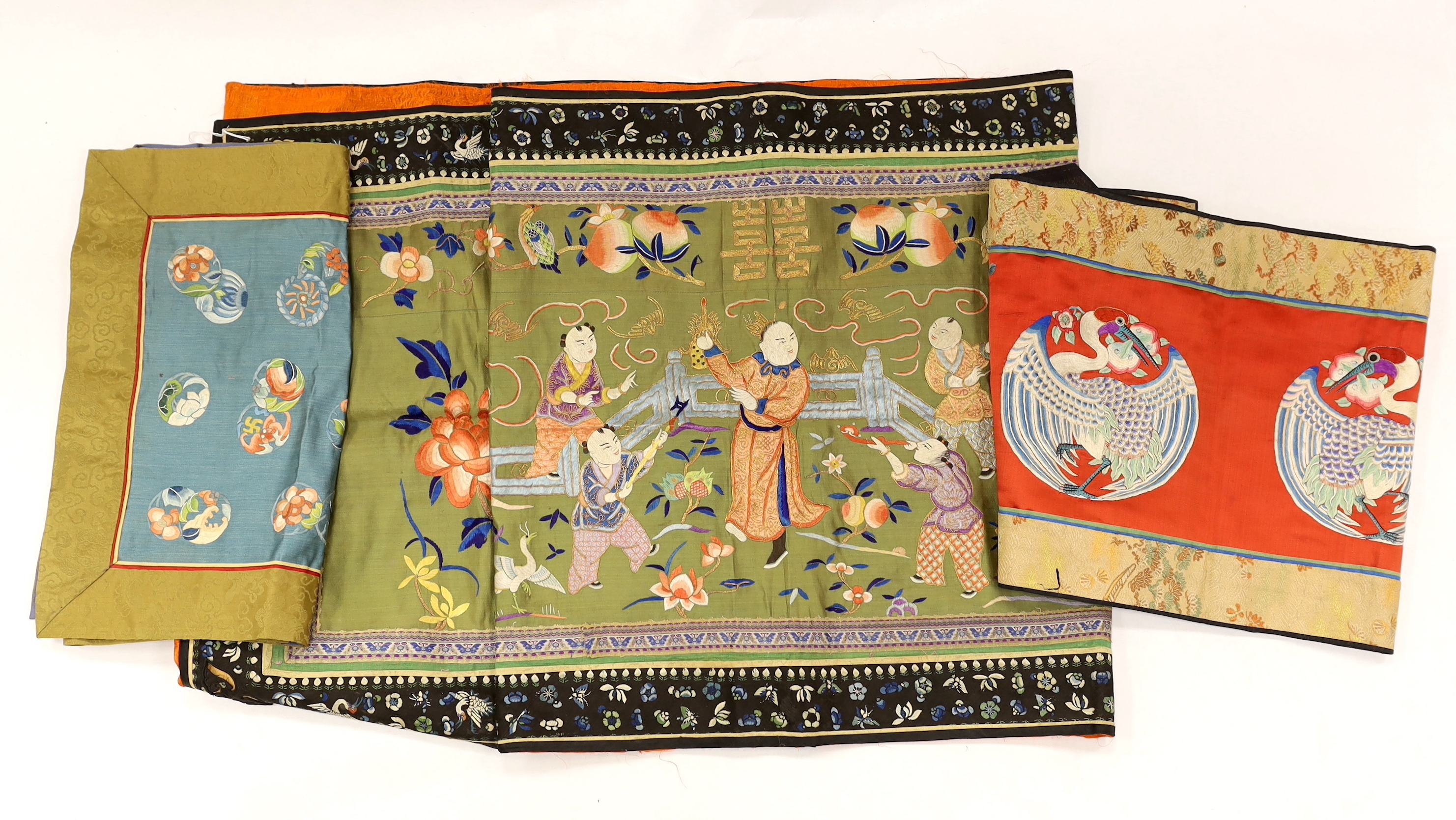 A long Chinese silk embroidered runner embroidered with the figure of Fu and boys, symbolic peaches, phoenix and flowers, possibly an altar cloth together with two other smaller runners, largest runner 202cm long x 55cm